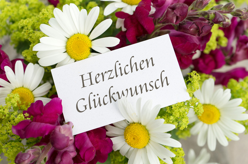Blumen mit Schild: Herzlichen Glückwunsch