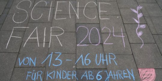 Aufschrift am Boden mit Kreide auf der Science Fair im Mai 2024