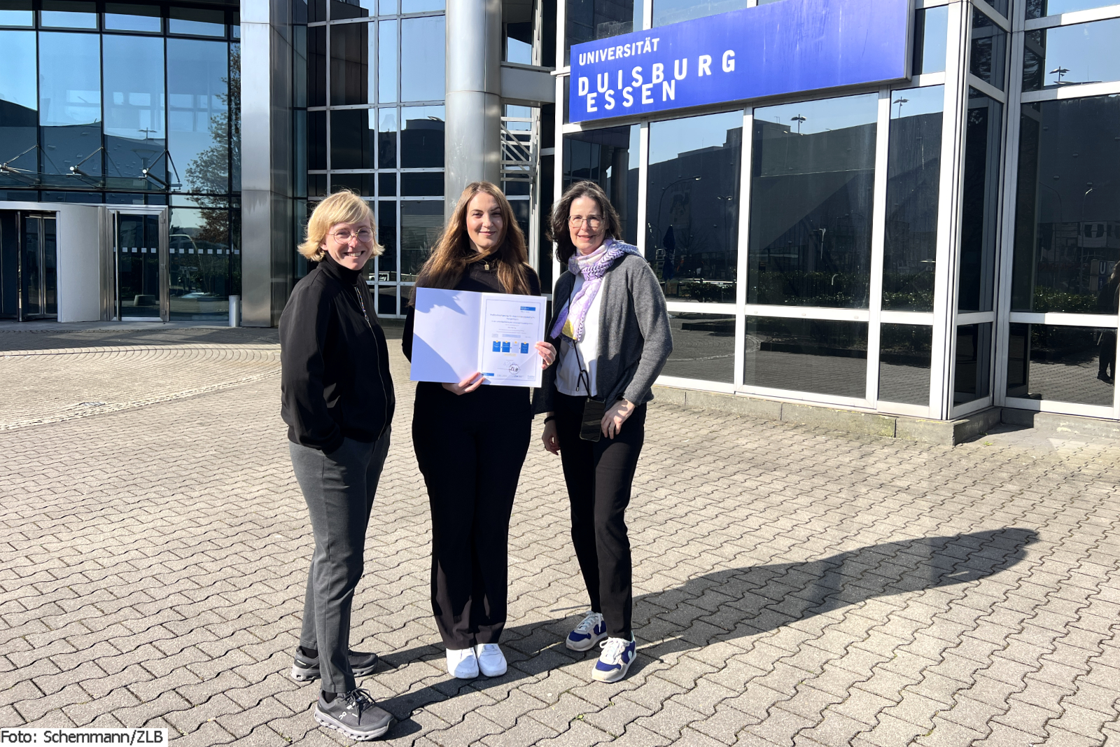 Drei Personen stehen vor dem Eingang der Weststadttürme